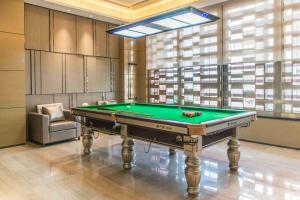 a pool table in a room with a window at Somerset Grandview Shenzhen in Shenzhen
