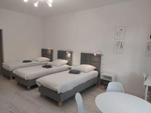 a room with three beds and a table and chairs at Apartament na weekend in Świdnica