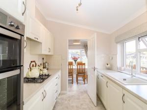 a kitchen with white cabinets and a sink at 12 Bucklesham Park in Ipswich