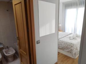 Un baño con un dormitorio con una cama y un lavabo. en Apartamento amplio, luminoso y confortable CC, en Madrid 23 fotos más