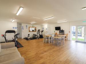 ein Wohnzimmer mit einem Sofa und einem Tisch mit Heimtrainern in der Unterkunft 12 Bucklesham Park in Ipswich