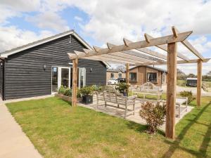 a wooden pergola in front of a house at 12 Bucklesham Park in Ipswich