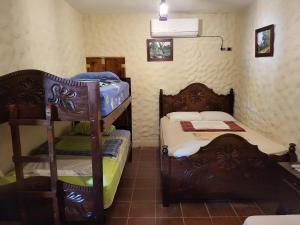 um pequeno quarto com 2 beliches e uma mesa em Hostal casa de las gargolas em Amapala