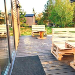 a wooden deck with a picnic table and benches at DORA in Łupawsko