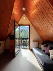 een woonkamer met een bank en een groot raam bij Logement 6 pers au cœur des montagnes pyrénéennes in Boutx