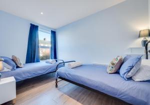 a room with two beds and a window at Beecroft Cottage in Cromer