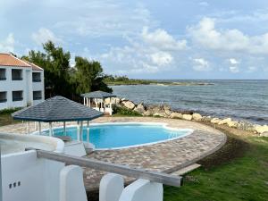 a swimming pool with a view of the ocean at OceanBlue Resort in Christ Church