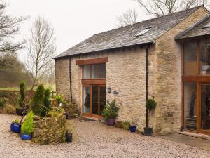 a stone house with plants in front of it at Willow Tree Barn in Kendal