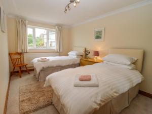 a bedroom with two beds and a window at Corner House in Cinderford