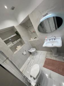 a white bathroom with a toilet and a sink at HOME SWEET HOME Storia di Napoli in Naples