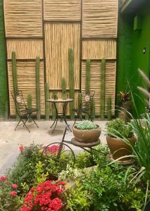 een patio met 2 stoelen, een tafel en bloemen bij Casa cómoda con patio a 4 cuadras de la catedral. in Oaxaca City
