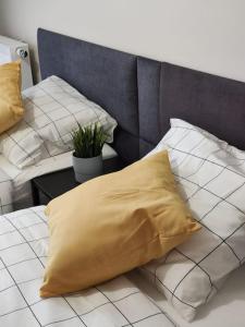 żółtą poduszkę siedzącą na łóżku w obiekcie Piękny apartament 3-pokojowy w mieście Katowice