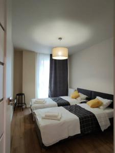 Pokój z 2 łóżkami i żyrandolem w obiekcie Piękny apartament 3-pokojowy w mieście Katowice