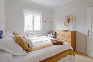 - une chambre avec un grand lit blanc et une fenêtre dans l'établissement Precioso alojamiento en zona histórica con garaje videovigilado, à Avilés