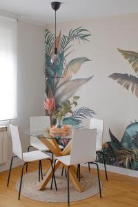 une salle à manger avec une table en verre et des chaises blanches dans l'établissement Precioso alojamiento en zona histórica con garaje videovigilado, à Avilés