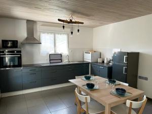 Il dispose d'une cuisine avec une table et des chaises. dans l'établissement La Cabane aux lacs ~ Maison cosy au calme, à Aureilhan
