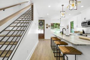 a kitchen with white walls and a staircase with stools at The Dream Catcher Home in Blue Ridge