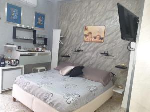 a bedroom with a bed and a tv on the wall at Lussuoso B&B in Palmi
