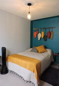 een slaapkamer met een bed en een blauwe muur bij Casa cómoda con patio a 4 cuadras de la catedral. in Oaxaca City