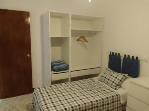 - une petite chambre avec un lit et un placard dans l'établissement Casa Lope de Vega, à El Pedroso