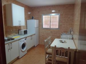 Il comprend une cuisine équipée d'une table et d'un réfrigérateur blanc. dans l'établissement Casa Lope de Vega, à El Pedroso