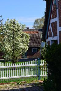 una cerca blanca frente a una casa en Ferienhof tom Diek, en Jork