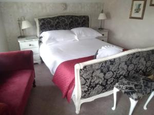 a bedroom with a white bed and a couch at Holly Tree B&B in Bromyard