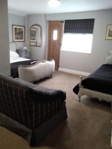 a bedroom with a couch and a bed and a window at Holly Tree B&B in Bromyard