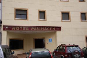 a hotel lobby with cars parked in front of a building at Hotel Mulhacen in Guadix