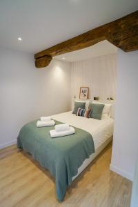 a bedroom with a large bed with two towels on it at Homely Rooms in Santander