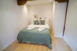 1 dormitorio con 1 cama con 2 toallas en Homely Rooms en Santander