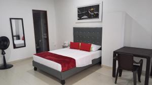 a bedroom with a bed and a desk and a chair at Hotel Ayenda La 44 Norte in Cali