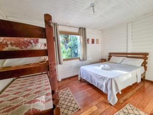 a bedroom with a bed and two bunk beds at Casa 4 dorms 2 suites - localização perfeita no centrinho e rodeada de natureza in Alto Paraíso de Goiás