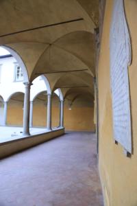 ein leeres Zimmer mit Säulen und einer Wand mit einem Gemälde an der Wand in der Unterkunft La Locanda di San Pier Piccolo in Arezzo