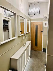 a room with a hallway with a sink and mirrors at City Apartment, 2 min walk to Norwich centre. in Norwich