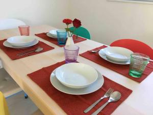 a table with white plates and red napkins and silverware at Kaoru Resort Enoshima - Vacation STAY 08572v in Fujisawa