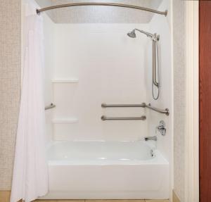 a bathroom with a shower with a white tub at Holiday Inn Express Hotel & Suites Burleson - Fort Worth, an IHG Hotel in Burleson