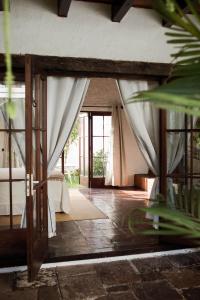 eine offene Tür zu einem Zimmer mit einem Bett und Vorhängen in der Unterkunft Cacao Boutique Hotel in Antigua Guatemala