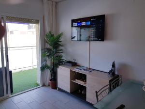 uma sala de estar com televisão na parede em AptoVistas al mar-Font de Mar en Cap de Salou em Salou