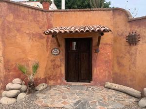 an orange building with a door and some rocks at Casa Xochitl in El Centenario