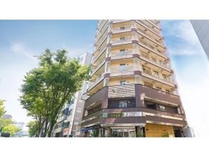 a tall building with a tree in front of it at Eins,Inn Umeda Higashi - Vacation STAY 30001v in Osaka