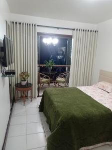 um quarto com uma cama, uma televisão e uma mesa em Flat no condomíno Monte Castelo em Gravatá-PE em Bezerros