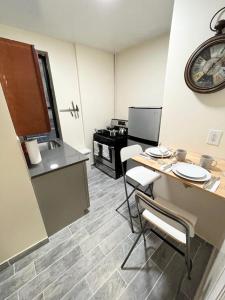 cocina con mesa, sillas y reloj en Beautiful private rooms in a shared apartment upper west side en Nueva York