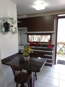 uma cozinha com uma mesa com cadeiras e um balcão em Flat no condomíno Monte Castelo em Gravatá-PE em Bezerros