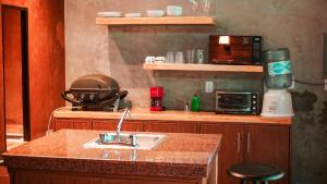 een keuken met een wastafel en een magnetron bij Villa Los Aguiluchos in Chetumal
