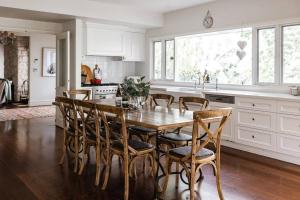 a kitchen with a wooden table and chairs at Nest on the Hill - A Luxurious Escape in Red Hill South