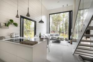 a kitchen and living room with white walls and windows at Polaris Villas in Muonio