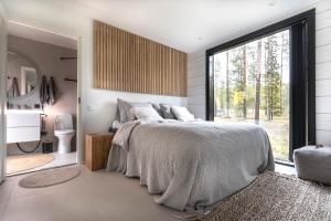 a bedroom with a bed and a large window at Polaris Villas in Muonio