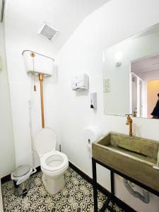 a bathroom with a toilet a sink and a bathtub at Hostal Macondo Bogotá in Bogotá