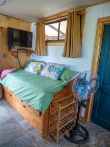 Ce lit se trouve dans une petite chambre dotée d'un ventilateur. dans l'établissement Uka O Te Ra´a Cabaña full equipada., à Hanga Roa